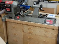 Lathe Closeup  My Nova DVR XP lathe sits between the sander and my workbench.  It has its own dust collection connection which works really well on small turnings like pepper mills and pens.  I haven't found a way to collect debris from bigger things like bowls. The lathe stand has two wide drawers for lathe tools.  The other drawers are for chucks, and other lathe accessories.